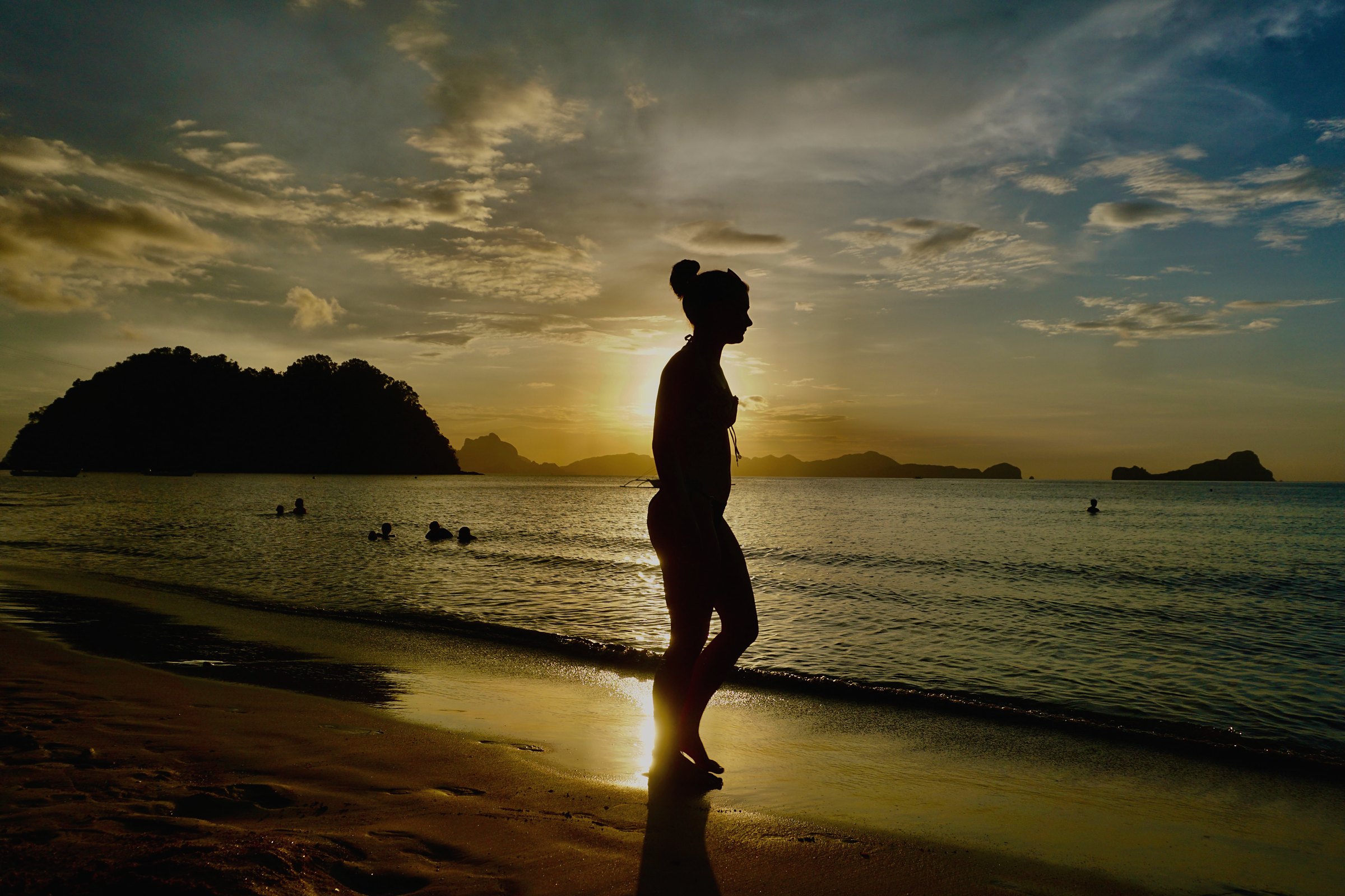 A sunset walk along the shore with islands on the horizon